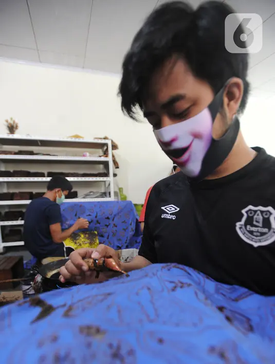 Perajin menyelesaikan proses pembuatan batik di  Batik Tradisiku, Bogor, Jawa Barat, Kamis (6/8/2020). Anjloknya penjualan batik mencapai 50 hingga 60 persen selama masa pandemi ini. (merdeka.com/Arie Basuki)