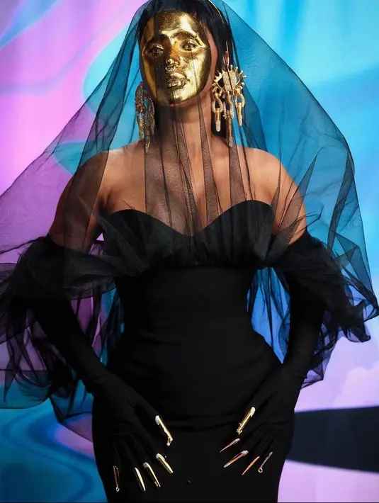 Cardi B mengejutkan public dengan penampilannya di karpet merah. Betapa tidak, rapper tersebut tampil dramatis dalam balutan gaun hitam dan topeng emas yang menutupi seluruh wajahnya. (Instagram/iamcardib)