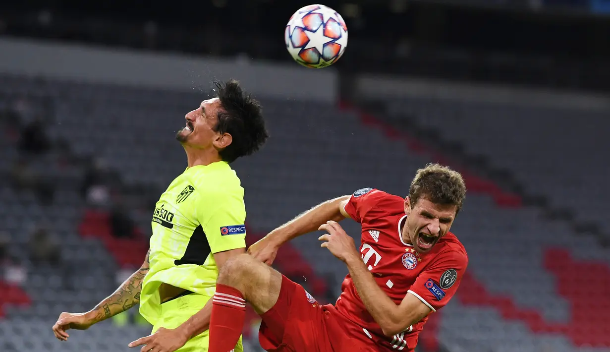 Penyerang Bayern Munchen, Thomas Mueller, berebut bola dengan bek Atletico Madrid, Stefan Savic, pada laga Grup A Liga Champions 2020/2021 di Allianz Arena, Kamis (22/10/2020) dini hari WIB. Bayern Munchen menang 4-0 atas Atletico Madrid. (AFP/Andreas Gebert/pool)