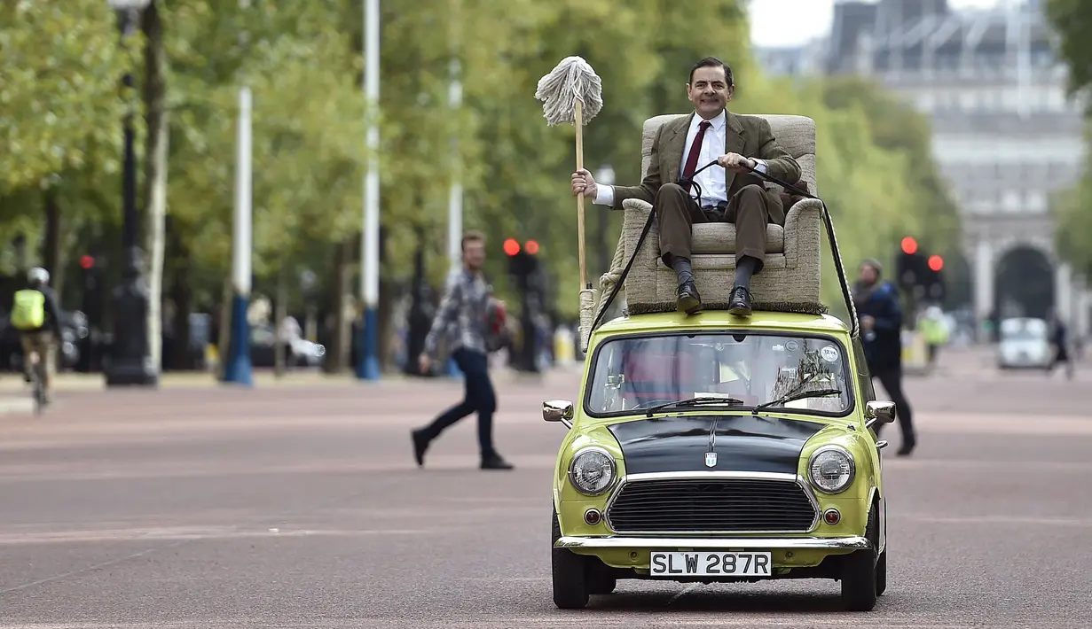 Rowan Atkinson, pemeran ‘Mr Bean’ membuat aksi lucu mengendarai mobil mini di atap mobil dan berkeliling di kawasan The Mall, London, Jumat (4/9/2015). Aksinya tersebut sebagai promosi serial TV dan Film komedi ‘Mr Bean’ (REUTERS / Toby Melville)