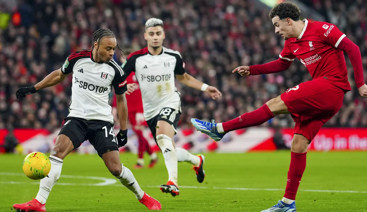 Gelandang Liverpool, Curtis Jones (kanan) melepaskan tendangan yang berusaha diblok striker Fulham, Bobby Decordova-Reid pada laga leg pertama babak semifinal Carabao Cup 2023/2024 di Anfield Stadium, Liverpool, Kamis (11/1/2024) dini hari WIB. (AP Photo/Jon Super)