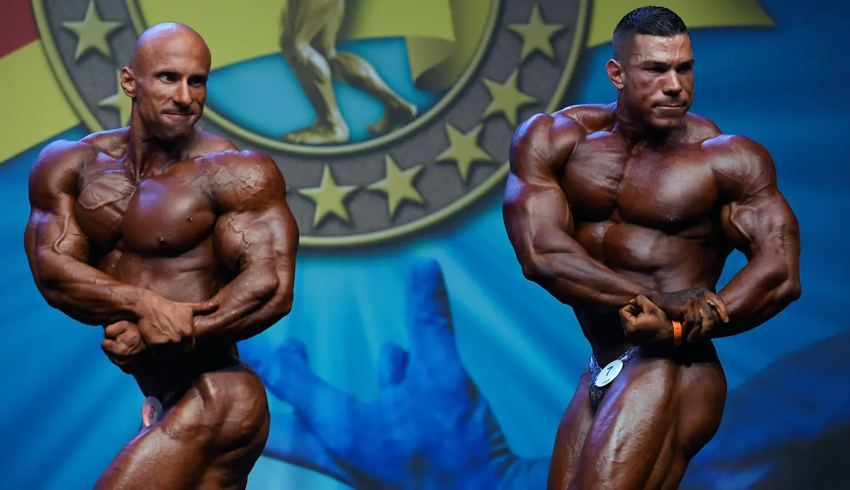 Binaraga Polandia, Szymon Lada dan binaraga Belanda Lorenzo Leeuwe memamerkan otot pada kontes Arnold Classic Europe 2019 di Barcelona, Sabtu (21/9/2019). Arnold Classic Europe merupakan kompetisi body builder yang akan berlangsung dari 20 hingga 22 September. (Photo by LLUIS GENE / AFP)