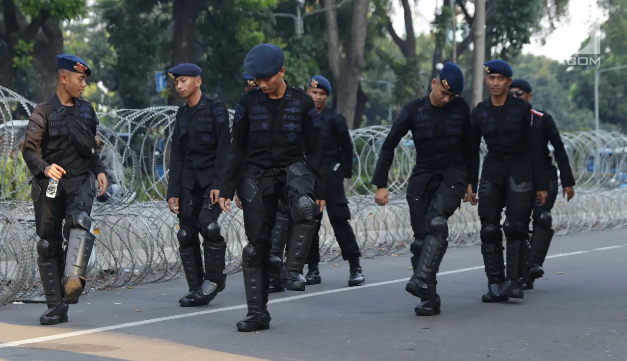 Personel Brimob menari bersama disela-sela berjaga di depan Gedung Mahkamah Konstitusi (MK), Jakarta, Selasa (25/6/2019). Jelang sidang pembacaan putusan akan digelar pada Kamis (27/6), penjagaan di sekitar Gedung Mahkamah Konstitusi diperketat. (Liputan6.com/Helmi Fithriansyah)