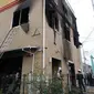 Petugas pemadam kebakaran memeriksa bangunan saat kebakaran melanda studio animasi Kyoto Animation di Kyoto, Jepang, Kamis (18/7/2019). Korban tewas kemungkinan akan bertambah mengingat tidak adanya tanda-tanda kehidupan di dalam studio. (JIJI PRESS/AFP)