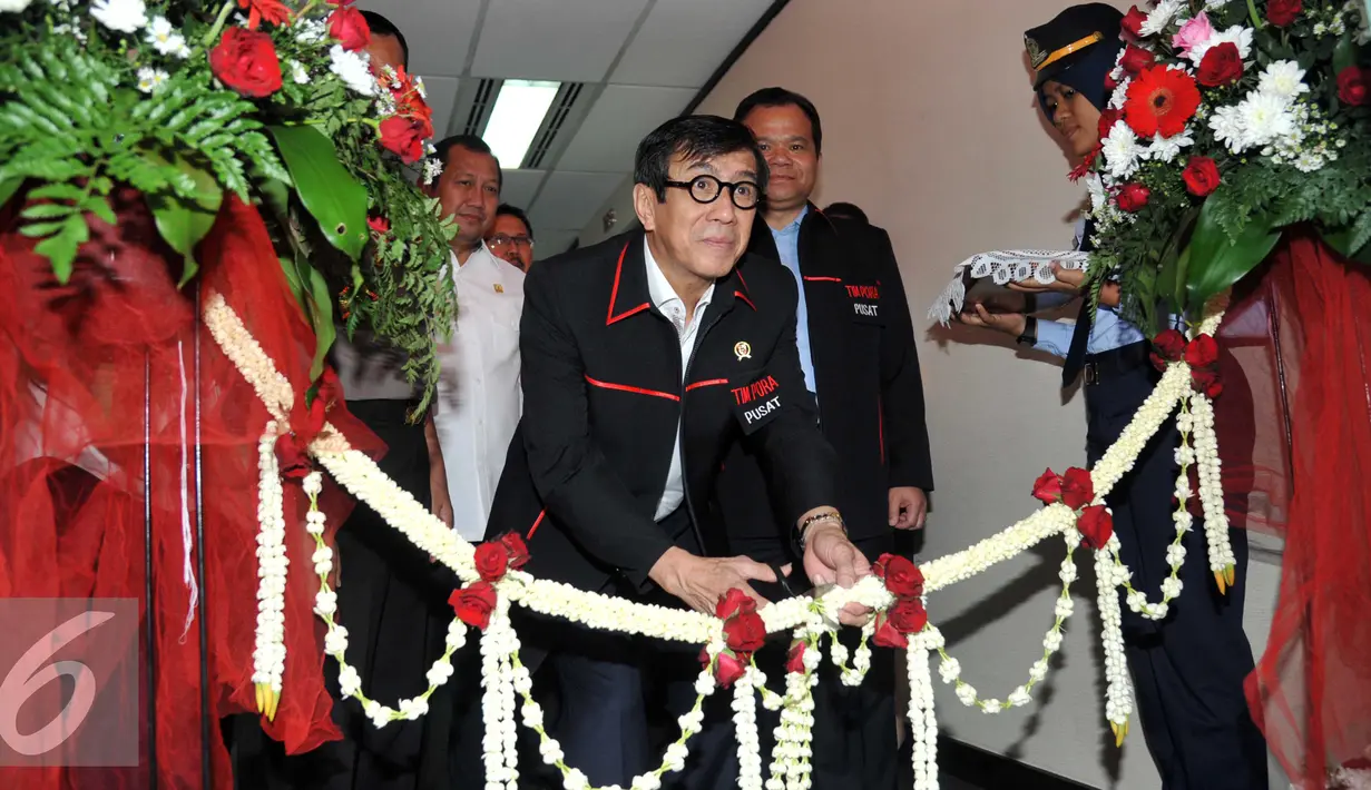 Menkumham Yasonna Laoly menggunting pita meresmikan tim Pengawasan Orang Asing  (PORA) di Gedung Imigrasi Kemenkumham, Jakarta (8/4). Dalam rangka menghadapi Masyarakat Ekonomi Asia (MEA) Menkumham meresmikan ruang timpora . (Liputan.com/Helmi Afandi)