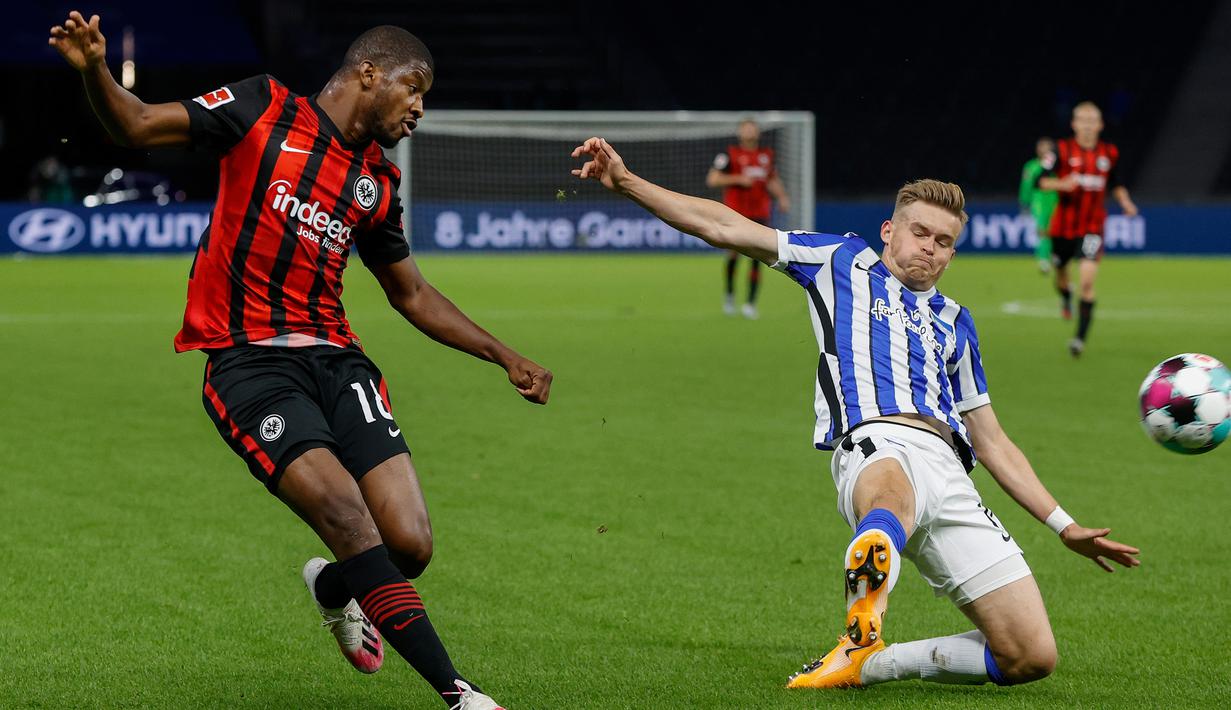 Bek Eintracht Frankfurt, Almamy Toure, berebut bola dengan bek Hertha Berlin, Niklas Stark, pada laga lanjutan Liga Jerman di Olympiastadion, Sabtu (26/9/2020) dini hari WIB. Frankfurt menang 3-1 atas Hertha Berlin. (AFP/Odd Andersen)