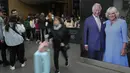 Wisatawan melewati potret besar Raja Charles III dan Ratu Camilla  yang dipajang di Stasiun Kings Cross di London, Senin, 1 Mei 2023. Penobatan Raja Charles III akan berlangsung di Westminster Abbey pada 6 Mei. (AP Photo/Kirsty Wigglesworth)