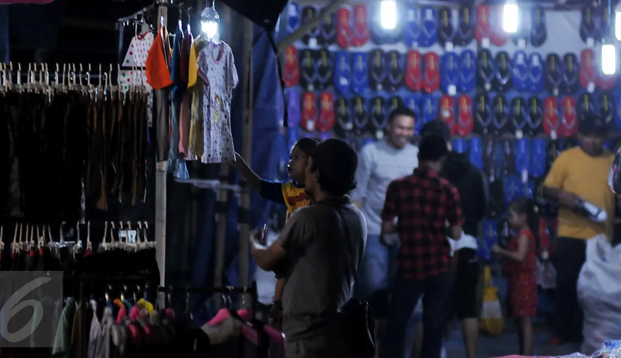 Warga melihat salah satu dagangan yang dijajakan di arena pasar malam di kawasan Pondok Aren, Tangsel, Senin (22/6). Di tengah hingar bingar bisnis hiburan malam modern, keberadaan pasar malam masih banyak diminati warga. (Liputan6.com/Johan Tallo)