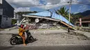 Sebuah sepeda motor berhenti di dekat bangunan yang runtuh pascagempa berkekuatan magnitudo 7,7 di Borong, Manggarai Timur, Nusa Tenggara Timur, Minggu, 16 Agustus 2026.. (AFP/ Juni Kriswanto)
