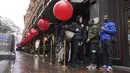Pembeli mengantre di tengah hujan untuk memulai penjualan 'Boxing Day' di department store di Knightsbridge, London, Minggu (26/12/2021).  'Boxing Day' adalah hari saat toko-toko di Inggris menggelar diskon besar-besaran, sehari setelah Natal. (Jonathan Brady/PA via AP)