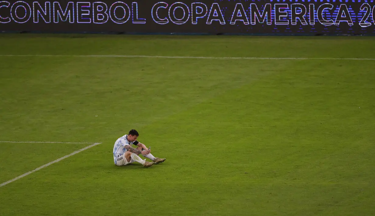 Penyerang Argentina, Lionel Messi berbicara di telepon setelah pertandingan final Copa America di stadion Maracana di Rio de Janeiro, Brasil, Minggu (11/7/2021). (AP Photo/Silvia Izquierdo)