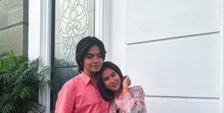 Model baju Lebaran couple Shena Cinnamon dan Angga Ayunda dengan nuansa peach. Shena memakai outerwear berpotongan kebaya viscose dan sarung lilit. (Foto: Instagram @shenacinnamon)