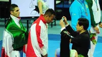 Karateka putra Indonesia Umar Syarief mendapat pengalungan medali perak usai pertandingan babak final Kumite +84 kg Asian Games Guangzhou XVI di Guangdong Gymnasium Guangzhou.(Antara)