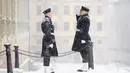 Penjaga kerajaan berdiri saat salju turun di luar Royal Castle di Stockholm, Swedia (28/1/2021). Ibu kota Swedia mungkin mendapatkan salju sepanjang hari. (Henrik Montgomery/TT via AP)
