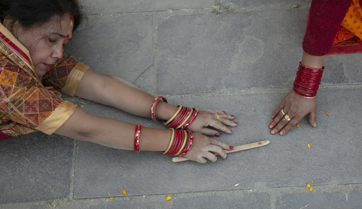 Seorang pemuja Hindu Nepal bergerak sambil berbaring sujud, sebagai bagian dari ritual, selama festival Chhath Puja di Kathmandu, Nepal, Rabu (10/11/2021). Selama Chhath, sebuah festival Hindu kuno, ritual dilakukan untuk terima kasih kepada Dewa Matahari. (AP Photo/Niranjan Shrestha)