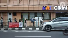 Calon penumpang kereta Commuter Line (KRL) melompati pagar saat hendak menuju Stasiun Cikini, Jakarta Pusat, Kamis (25/5/2023). (merdeka.com/Iqbal S.Nugroho)