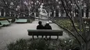 Orang-orang duduk di taman Palais Royal di Paris (22/3/2021).  Penduduk Paris dan beberapa wilayah Prancis lainnya menghabiskan akhir pekan pertama mereka di bawah penguncian terbatas selama sebulan.  (AP Photo/Lewis Joly)
