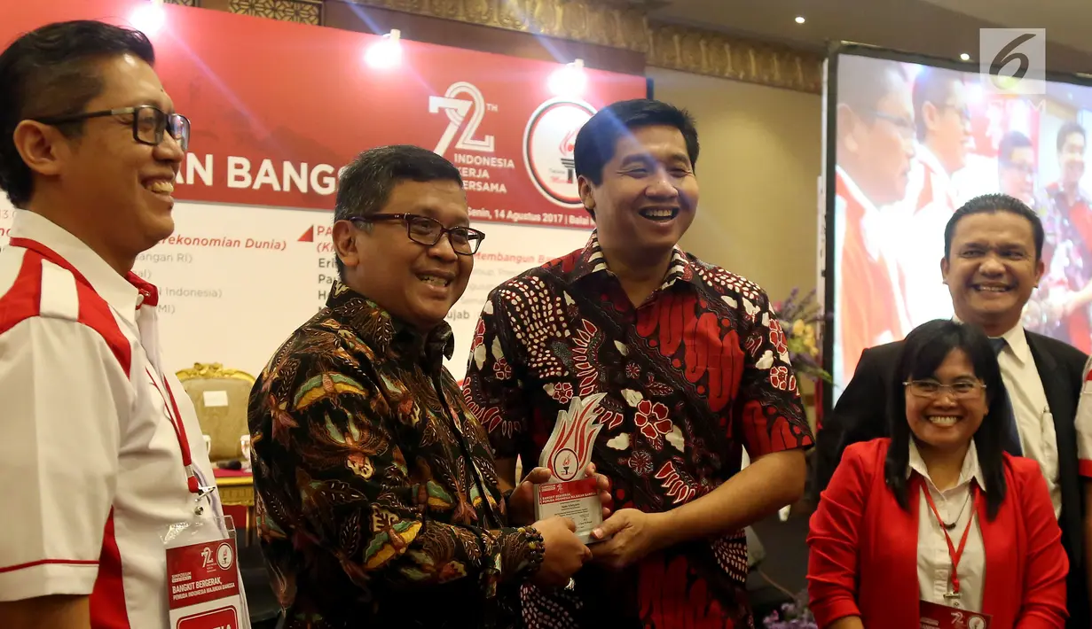 Ketua Umum Taruna Merah Putih Maruarar Sirait memberikan cendera mata kepada Sekertaris Jenderal Partai PDI Perjuangan Hasto Kristiyanto di acara Simposium Nasional di Jakarta, Senin (14/8). (Liputan6.com/Johan Tallo)