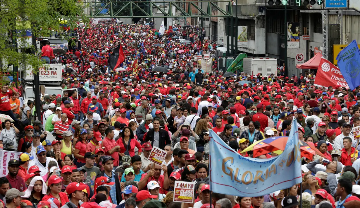 Pendukung Presiden Venezuela, Nicolas Maduro ikut ambil bagian dalam unjuk rasa memperingati May Day 2016 atau Hari Buruh Sedunia di Caracas, Minggu (1/5). Di beberapa negara, peringatan buruh sempat diwarnai dengan aksi bentrok. (REUTERS/Marco Bello)