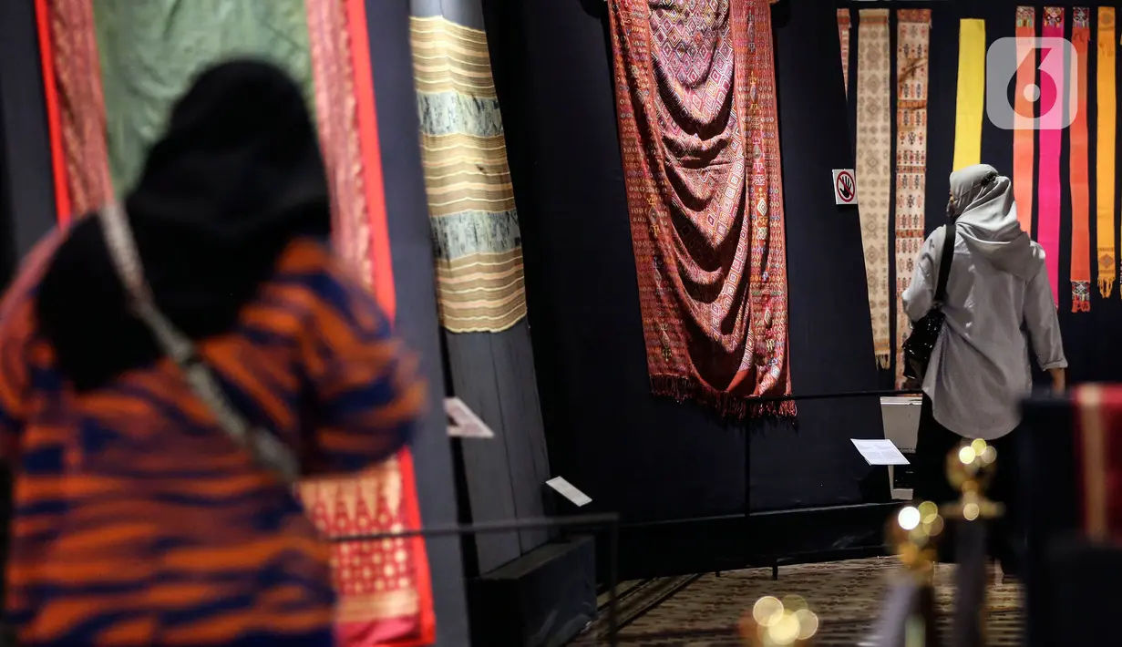 Pengunjung melihat kain tenun di pameran tenun bertajuk "Nuansa Kemilau Wastra Tenun Indonesia" di Museum Tekstil, Jakarta, Rabu (20/7/2022). Pameran dalam rangka memperingati HUT ke - 77 RI ini berlangsung hingga 31 agustus 2022 mendatang dan menampilkan kerajinan tenun dari Sumatera, Sulawesi, dan Timor. (Liputan6.com/Johan Tallo)