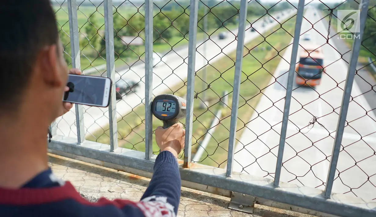 Petugas mengoperasikan alat pengukur kecepatan (speed gun) kendaraan di sekitar Gerbang Tol Palimanan, Cirebon, Jawa Barat, Jumat (7/6/2019). Hal itudilakukan setiap satu jam sekali untuk mengetahui tingkat kepadatan lalu lintas di sepanjang jalur tol Trans Jawa. (Liputan6.com/Immanuel Antonius)
