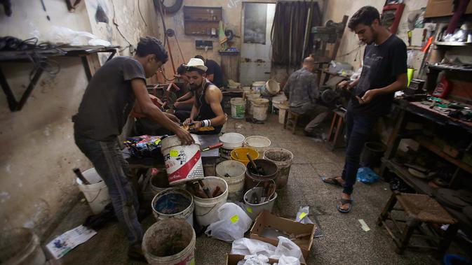 Para pria Palestina menajamkan pisau yang akan digunakan untuk menyembelih hewan kurban dalam perayaan Idul Adha di sebuah lokakarya di Kota Gaza, 28 Juli 2020. Idul Adha merupakan salah satu tanggal penting dalam kalender Islam. (AP Photo/Hatem Moussa)