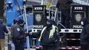 Petugas polisi yang berkumpul melawan dingin saling menyapa di New York, Selasa (11/1/2022). Massa udara kutub utara menyapu timur laut AS, membawa suhu di bawah nol yang menusuk tulang dan menutup sekolah di seluruh wilayah untuk kedua kalinya dalam waktu kurang dari seminggu. (AP/Seth Wenig)