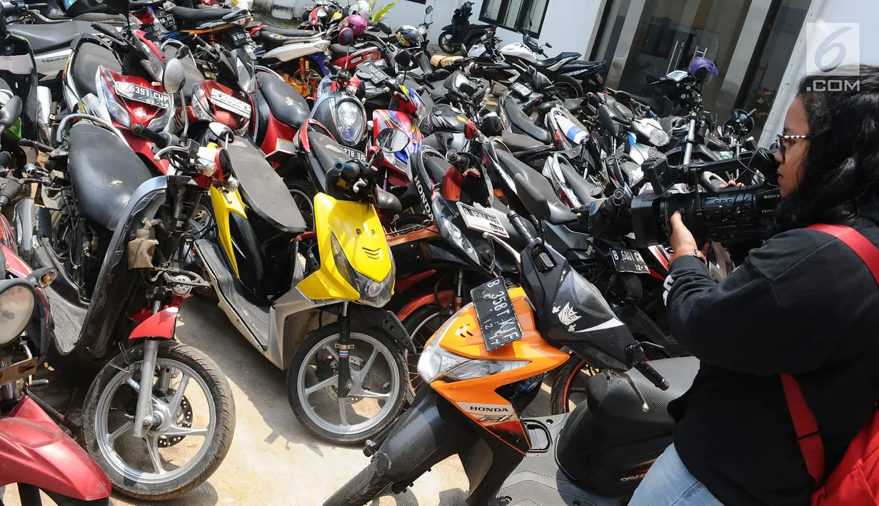 Awak media mengambil gambar motor yang dikendarai Adi Saputra (21) di Polres Tangerang Selatan, Jumat (8/2).  Adi Saputra merusak motor matik-nya lantaran tidak terima ditilang polisi di kawasan BSD pada Kamis (7/2) kemarin. (Liputan6.com/Herman Zakharia)