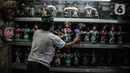 Masudi alias Bang Ntong Salam (40) menata sejumlah miniatur ondel-ondel di Jalan Gang 3, Kelurahan Pondok Kopi, Kecamatan Duren Sawit, Jakarta Timur, Selasa (19/10/2021). (merdeka.com/Iqbal S. Nugroho)