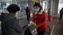 Petugas menyemprotkan sanitizer ke pengunjung di dalam Pyongyang Department Store No. 1, Korea Utara (28/12/2020). Meski Korea Utara melaporkan nol kasus Covid-19, pemerintahan Pyongyang tetap menerapkan standar protokol kesehatan guna mencegah penyebaran Covid-19. (AFP/Kim Won Jin)