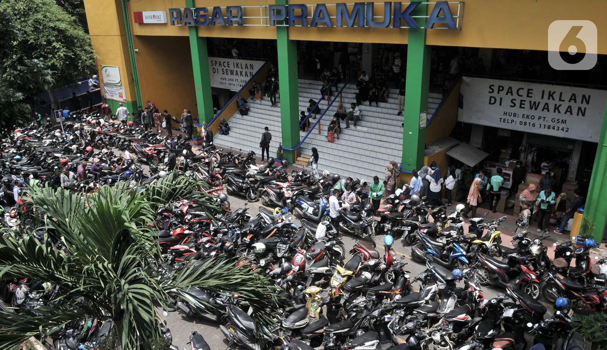 Parkiran sepeda motor pengunjung di Pasar Pramuka, Jakarta, Senin (16/3/2020). Pasar Pramuka diserbu pembeli yang mencari masker guna mengantisipasi virus Corona Covid-19, membuat sebagian badan jalan dimanfaatkan sebagai parkiran sehingga menyebabkan kemacetan panjang. (merdeka.com/Iqbal Nugroho)