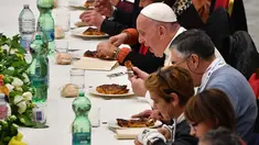 Paus Fransiskus (kanan) menyantap makan siang bersama sejumlah orang miskin di Pope Paul VI hall, Vatikan, Minggu (18/11). Makan siang bersama ratusan kaum papa, tunawisma, dan pengangguran itu memperingati Hari Orang Miskin Sedunia. (Vincenzo PINTO/AFP)