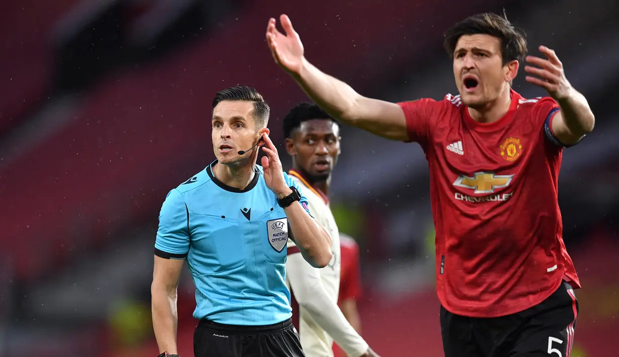 Ekspresi kecewa bek Manchester United, Harry Maguire (kanan) usai wasit memberi hadiah penalti kepada AS Roma dalam laga leg pertama semifinal Liga Europa 2020/2021 di Old Trafford Stadium, Manchester, Kamis (29/4/2021). Manchester United menang 6-2 atas AS Roma. (AFP/Paul Ellis)