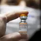 Seorang pekerja kesehatan Israel menunjukkan botol vaksin Covid-19 Pfizer/BioNTech Covid-19 untuk anak-anak di Meuhedet Healthcare Services Organization di Tel Aviv, saat Israel memulai kampanye vaksinasi virus corona untuk anak berusia 5 hingga 11 tahun, Senin (22/11/2021). (JACK GUEZ / AFP)