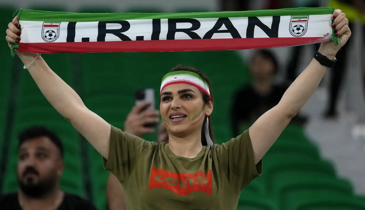 Seorang fans wanita Iran mengangkat syal sebelum dimulainya pertandingan grup B Piala Dunia antara Iran dan Amerika Serikat di Stadion Al Thumama di Doha, Qatar, Selasa, 29 November 2022. (AP Photo/Manu Fernandez)