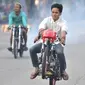 Seorang pembalap mengangkat sepeda motornya saat ikut dalam balapan liar di Jakarta, Minggu (27/5) pagi. Mereka memanfaatkan sepinya arus lalu lintas kendaraan untuk balapan liar. (Merdeka.com/Iqbal S Nugroho)