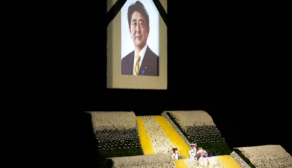 Potret mantan Perdana Menteri Jepang Shinzo Abe terlihat pada altar saat pemakaman kenegaraannya di Nippon Budokan, Tokyo, Jepang, 22 September 2022. Sekitar 60 persen orang mengatakan mereka tidak mendukung prosesi pemakaman tersebut. (AP Photo/Eugene Hoshiko, Pool)