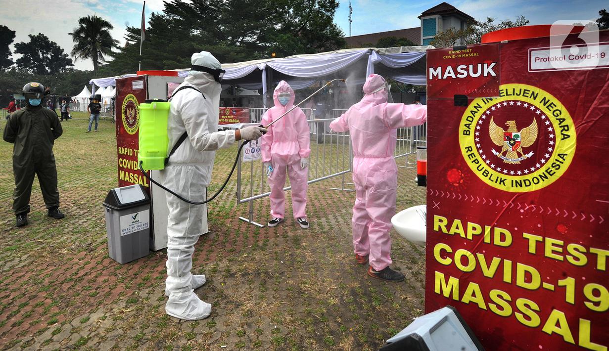 Petugas medis disemprot cairan disinfektan saat rapid test oleh BIN di Lapangan Kantor Kecamatan Pamulang, Tangerang Selatan, Banten, Kamis (2/7/2020). BIN menggelar rapid test gratis terhadap 800 warga Pamulang untuk memutus mata rantai penyebaran virus corona COVID-19. (merdeka.com/Arie Basuki)