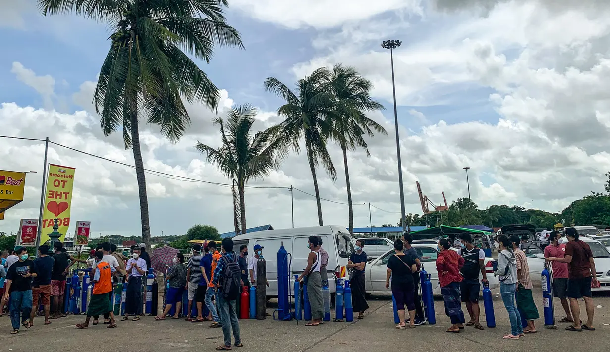 Orang-orang antre menunggu di lokasi yang menyumbangkan oksigen secara gratis di Yangon, Myanmar pada 14 Juli 2021. Mereka putus asa mencari oksigen untuk menjaga orang yang dicintai tetap bernapas ketika gelombang corona covid-19 menerjang negara yang dilanda kudeta itu. (Ye Aung THU/AFP)