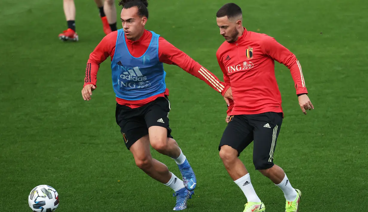 Bek Belgia, Arthur Theate (kiri) mengontrol bola dari kejaran gelandang Eden Hazard selama sesi latihan di Tubize (5/10/2021). Belgia akan bertanding melawan Prancis pada semifinal UEFA Nations League di Allianz Stadium. (AFP/Belga/Virginie Lefeour)