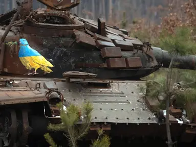 Sebuah tank Rusia yang hancur bergambarkan burung merpati dengan cabang zaitun karya seniman jalanan terkenal TvBoy di tengah serangan Rusia terhadap Ukraina di Desa Dmytrivka, luar Kyiv, Ukraina, 30 Januari 2023. Karya seni yang dibuat untuk menghormati para korban perang Rusia-Ukraina tersebut mengandung pesan kelahiran kembali dan harapan serta berharap agar konflik segera berakhir. (AP Photo/Efrem Lukatsky)