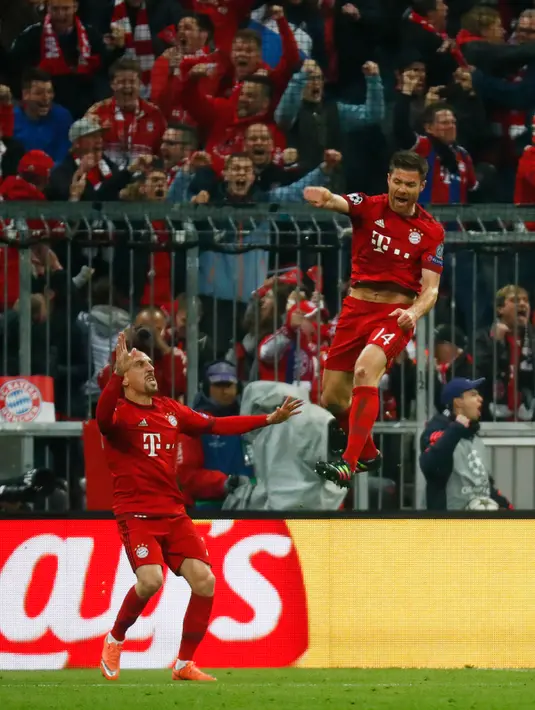 Gelandang Muenchen, Xabi Alonso (kanan) melakukan selebrasi usai mencetak gol kegawang Atletico Madrid di Liga Champions di Allianz Arena (4/5). Meski kalah 2-1 dari Munchen, Atletico melaju ke final dengan aggregat gol tandang. (Reuters/Kai Pfaffenbach)