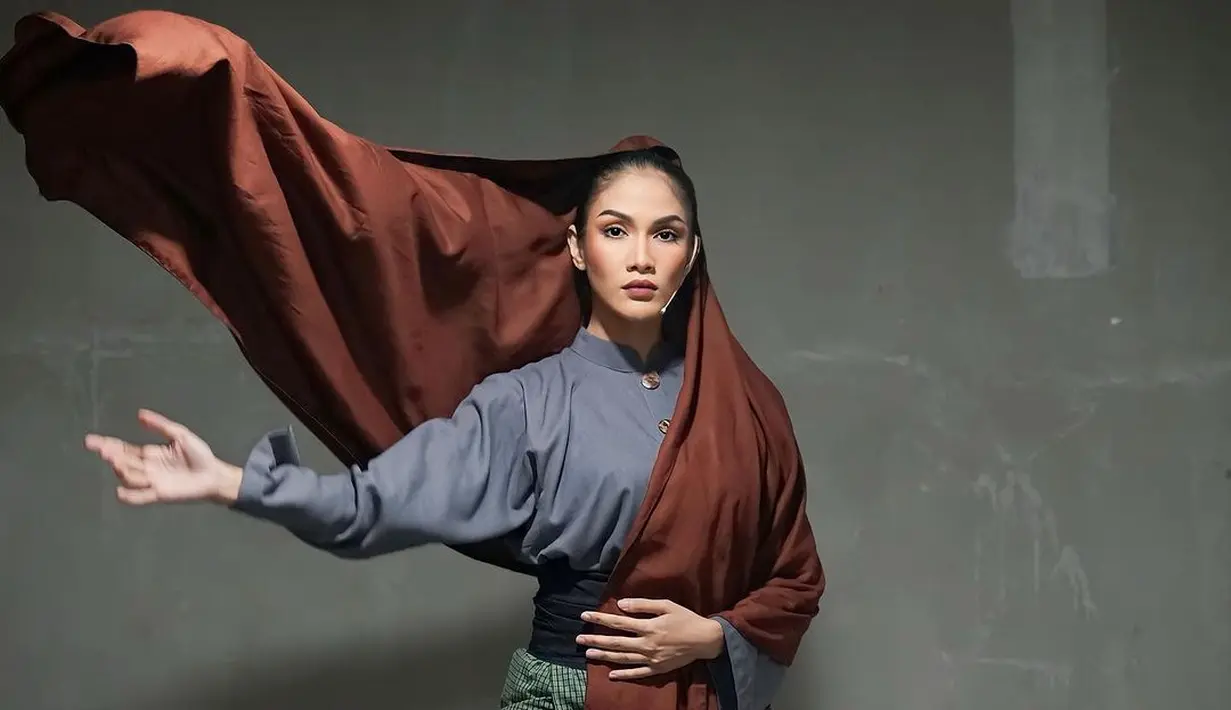 Dalam sebuah photoshoot, Aulia Sarah tampil memukau memadukan atasan biru dengan bawahan kotak-kotak hijau putih, selendang cokelat yang menutupi kepalanya, dan obi hitam polos. [Foto: Instagram/owliasarah]