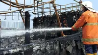 Petugas terus memadamkan kapal yang terbakar di Pelabuhan Muara Baru, Jakarta. (Liputan6.com/ Ady Anugrahadi)