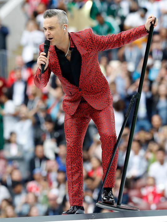Penampilan penyanyi asal Inggris, Robbie Williams pada upacara pembukaan Piala Dunia 2018 di Stadion Luzhniki, Moskow, Kamis (14/6). Robbie Williams yang mengenakan jas setelan berwarna merah langsung menggebrak seisi Luzhniki Stadium. (AP/Antonio Calanni