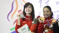 Atlet Wushu Indonesia, Juwita Niza (kanan) dan Ivana Ardelia saat menerima medali pada Kejuaraan  Dunia Wushu 2015 di Istora, Senayan, Jakarta, Selasa(16/11/2016). (Bola.com/Nicklas Hanoatubun).