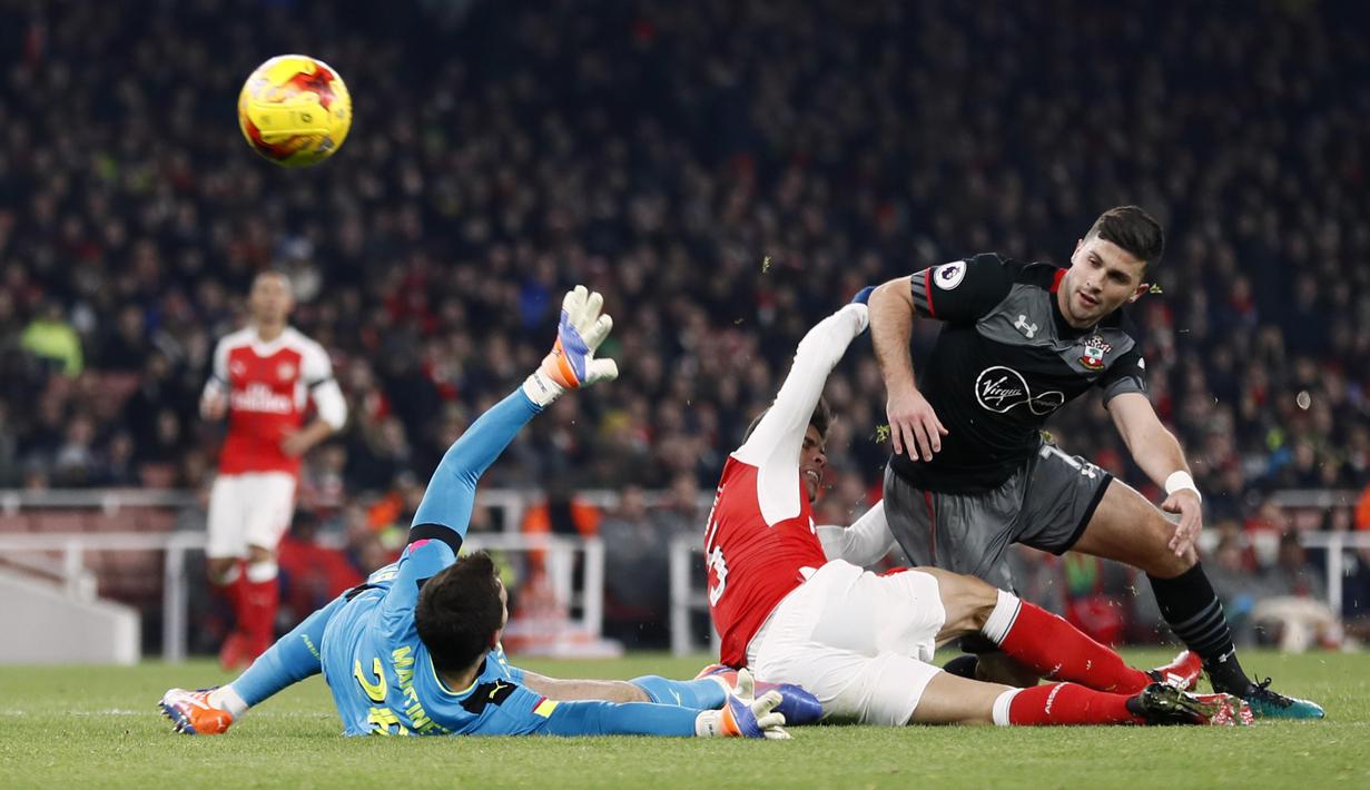 Pemain Arsenal, Gabriel Paulista (tengah) dan kiper Arsenal, Emiliano Martinez,  menghadang sepakan pemain Southampton, Shane Long  pada laga Piala Liga Inggris 2016-2017 di Emirates Stadium, (30/11/2016).  (Reuters/Stefan Wermuth)
