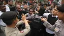 Polisi terlibat aksi saling dorong saat berusaha membubarkan massa FRI-WP dan AMP di Jalan Medan Merdeka Barat, Jakarta, Selasa (15/8). Kericuhan terjadi akibat polisi melarang aksi di depan Istana Negara. (Liputan6.com/Immanuel Antonius)