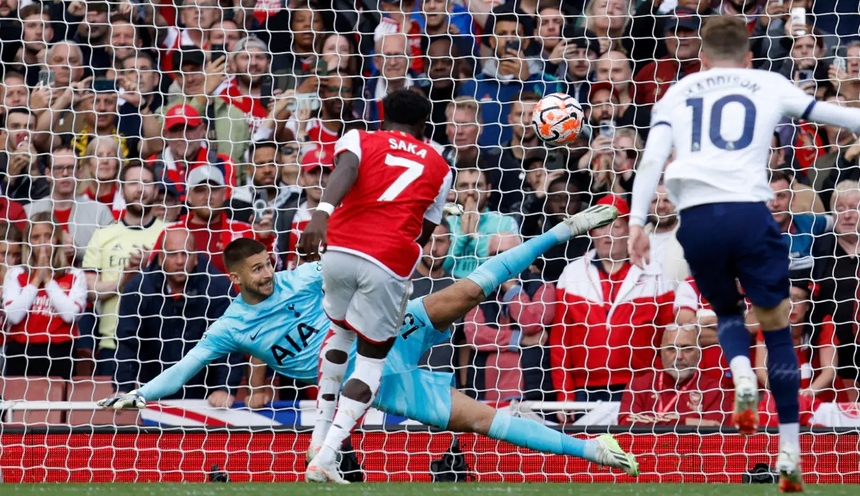 Memasuki menit ke-49, Arsenal mendapatkan hadiah penalti karena Cristian Romero hand ball di area terlarang. Bukayo Saka yang menjadi algojo sukses memperdayai kiper Tottenham Guglielmo Vicario. Tetapi, skor 2-1 untuk keunggulan Arsenal tidak bertahan lama. (AP Photo/David Cliff)