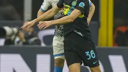 Bek Napoli Mario Rui dan bek Inter Milan Matteo Darmian  melompat saat berebut bola dalam lanjutan Liga Italia di Giuseppe Meazza, Senin (22/11/2021) dini hari WIB. Inter Milan sukses mengandaskan Napoli dengan skor tipis 3-2. (AP Photo/Antonio Calanni)